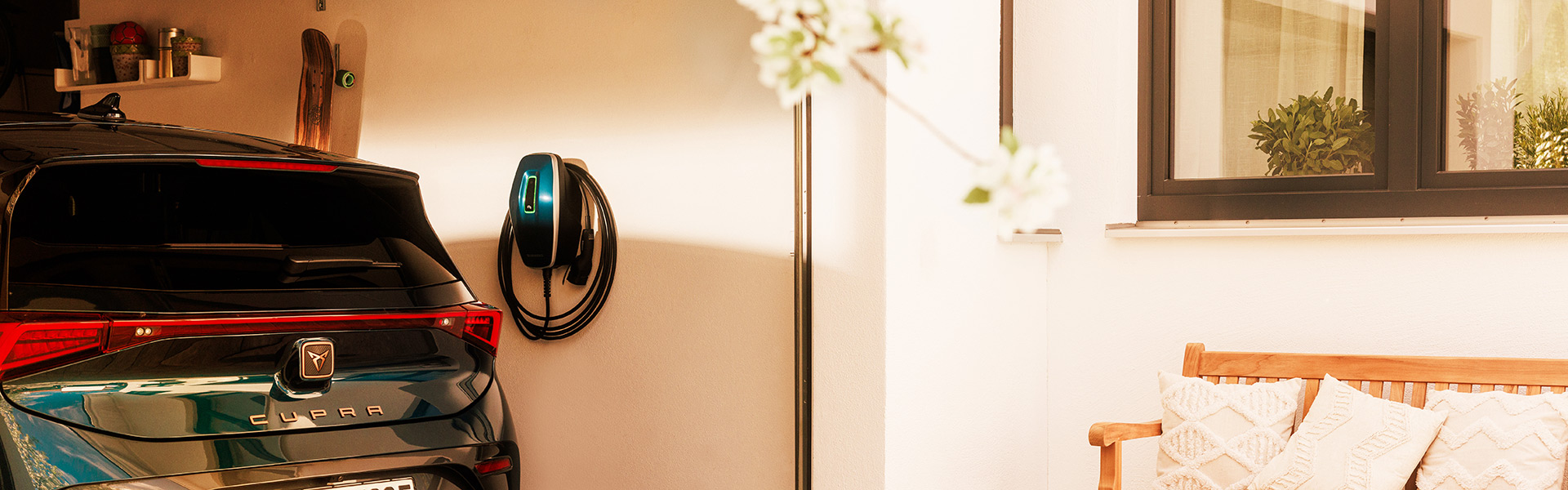 Blaue Wallbox AMTRON 4You 300 hängt in der Garage neben einem E-Auto  