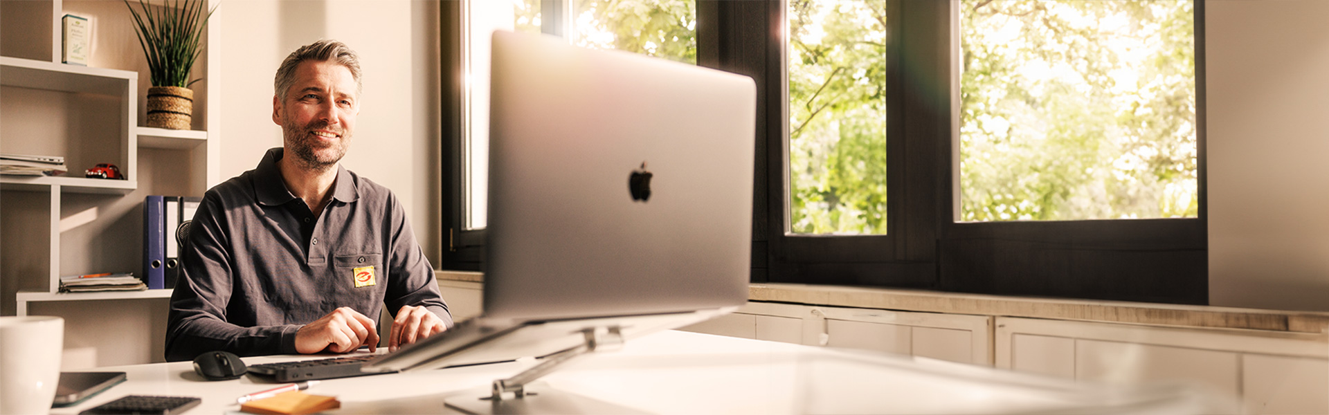 Installateur am Schreibtisch vor Laptop 