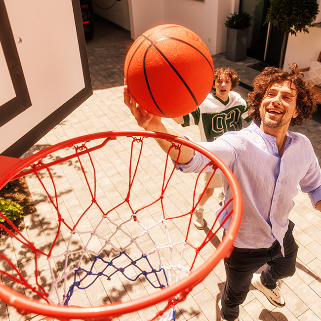 Mann wirft Basketball in Korb 